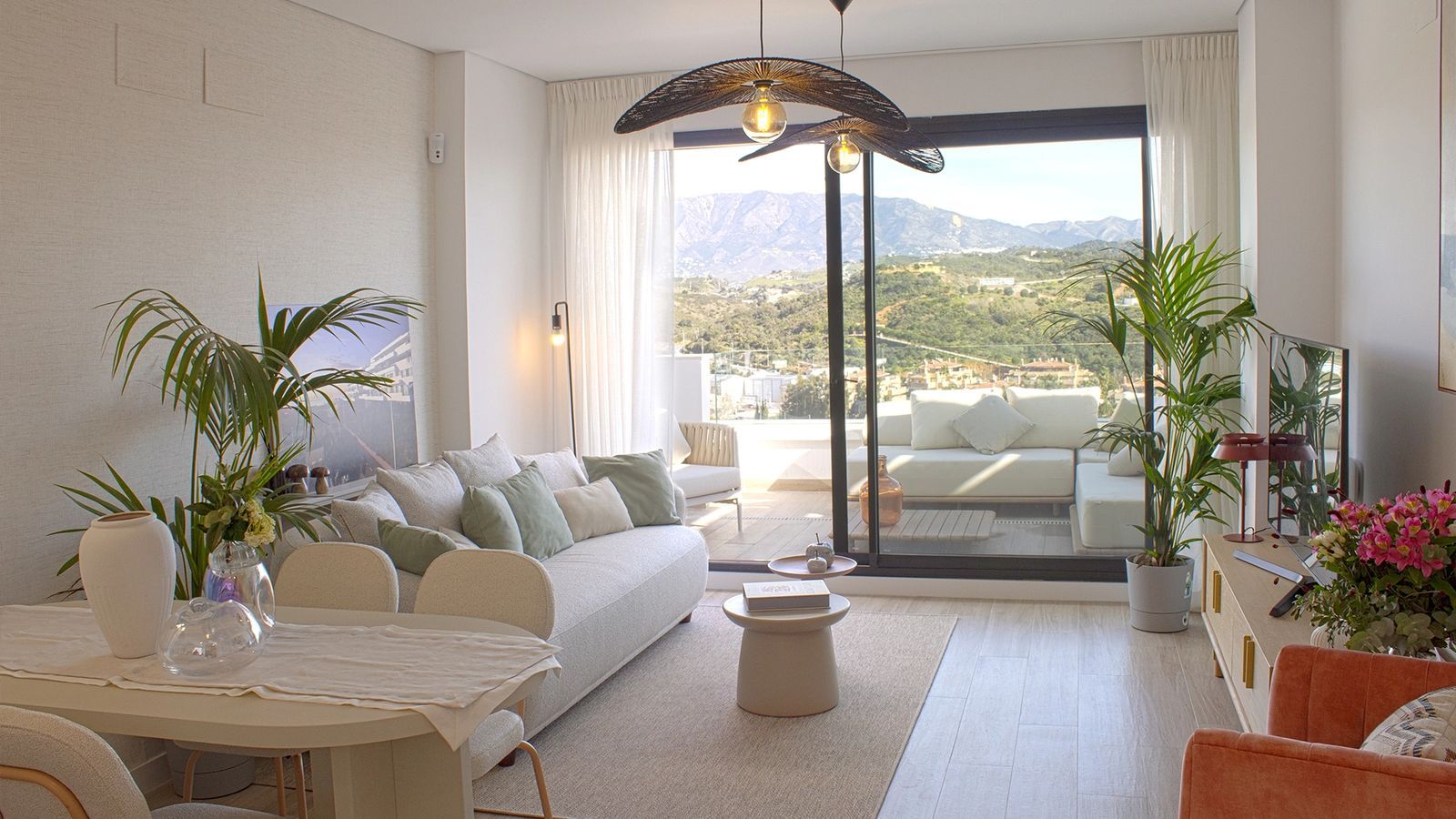 Modern living room with white sofa, large windows, and mountain views at Navigolf Suites 2.